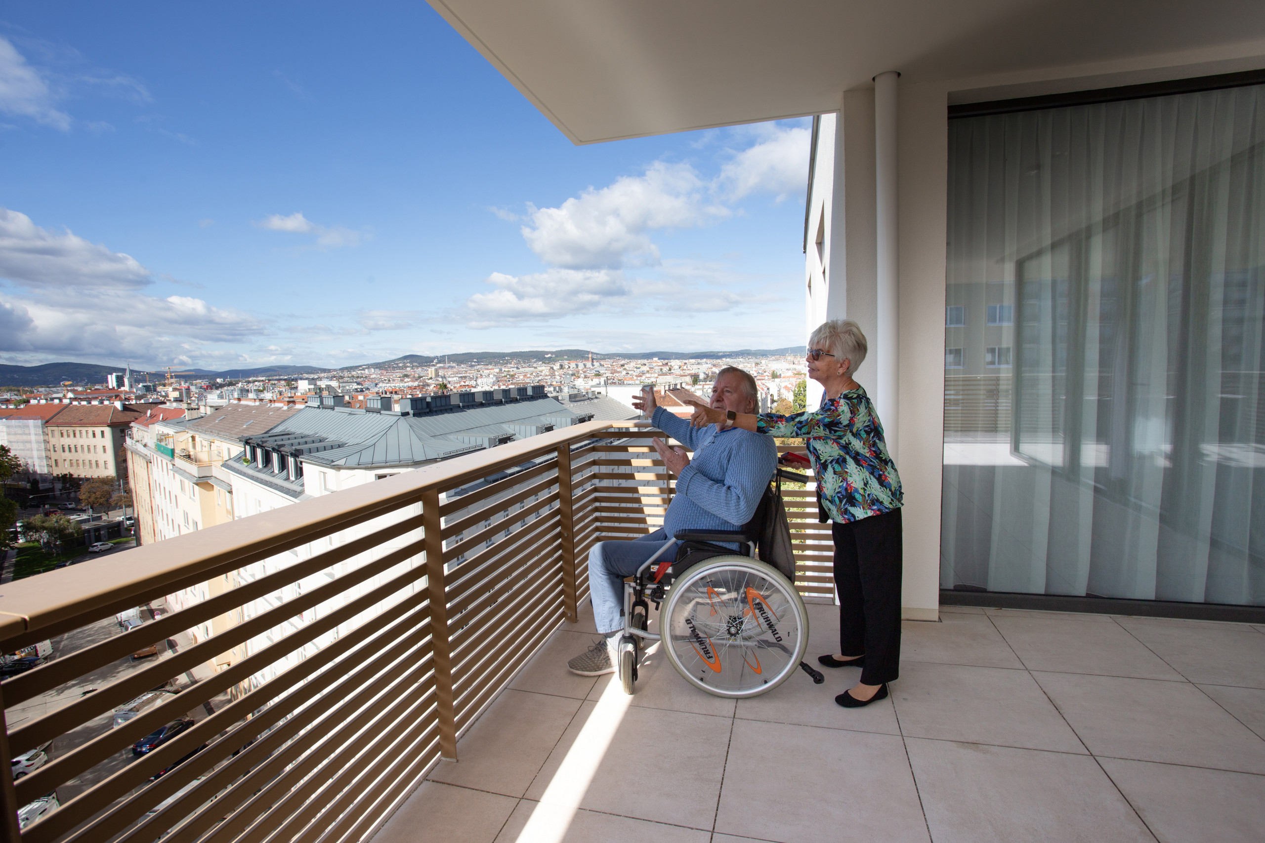 Senioren genießen den Blick über Wien auf einer Terasse des ÖJAB-Pflegewohnhauses Neumargareten.