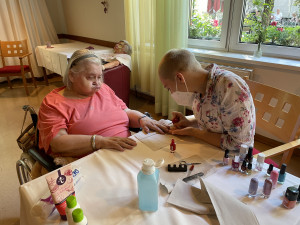 Bewohnerin erhält eine Maniküre von PflegemitarbeiterIn.
