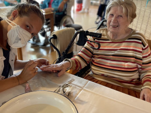 Bewohnerin erhält eine Maniküre von PflegemitarbeiterIn.