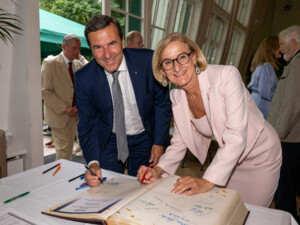 Generaldirektor-Stellvertreter der Raiffeisenlandesbank Niederösterreich-Wien Reinhard Karl und Landeshauptfrau Johanna Mikl-Leitner tragen sich während der Feierlichkeiten in das Goldene Buch der ÖJAB ein. Foto: NLK Burchhart