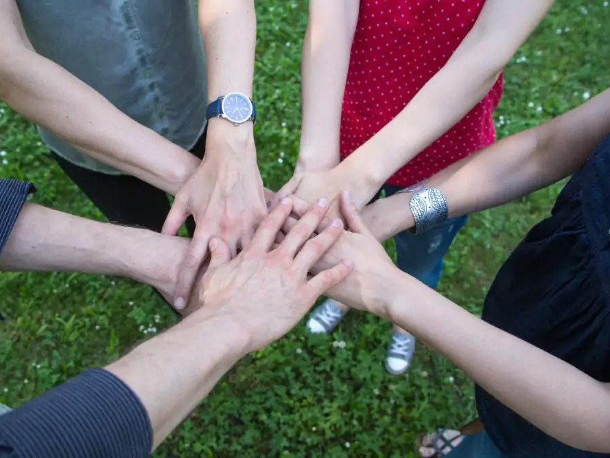 Symbolic image of a Team building with hands on top of each other.