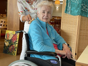 Bewohnerin erhält eine Rückenmassage von PflegemitarbeiterIn.