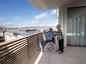 Zwei BewohnerInnen auf einer Terrasse des Hauses bewundern die Aussicht auf Wien.