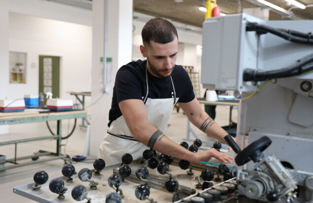 Ein junger Mann, der an einer Glasschneidemaschine arbeitet