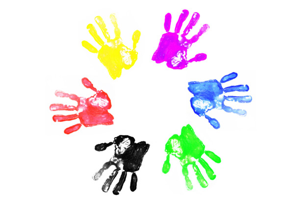 Ein Kreis aus sechs farbigen Handabdrücken auf weißem Hintergrund. Die Handabdrücke sind in den Farben Rot, Gelb, Pink, Blau, Grün und Schwarz dargestellt und bilden eine gleichmäßige Anordnung, die an ein Rad erinnert. Das Motiv steht für Diversität, Inklusion und gemeinschaftliches Miteinander.