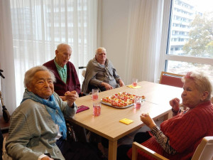 BewohnerInnen an einem Tisch im neuen ÖJAB-Pflegewohnhaus sitzend und belegte Brötchen essend.