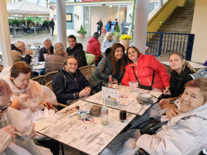 Bewohner:innen und Mitarbeiter:innen sitzend im Schweizerhaus im Prater.