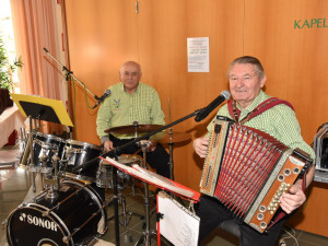 Die Musikanten Rudi und Ernst sitzend vor ihren Instrumenten.