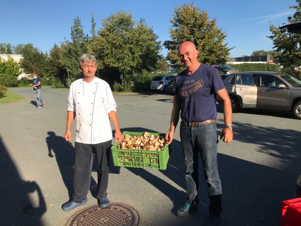 Karl Krammer vom ÖJAB Haus St Franziskus übergibt Küchenchef Jürgen Minixhofer Schwammerl für die BewohnerInnen.