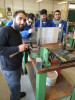 Foto 1: Grundlagenunterricht für MANA-TeilnehmerInnen in der Mechanischen Werkstätte an der HTL Mödling. Eine Metallwerkstück wird nach dem auf dem Glas montierten Plan bearbeitet.