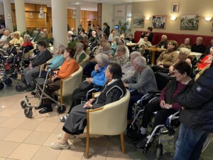 Die Zuhörer:innen beim Gesang des Volkschores in der Eingangshalle des Pflegewohnhauses.