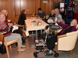 BewohnerInnne und Angehörige sitzen gemütlich beisammen und genießen das Fest.