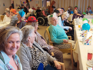 BerwohnerInnen und MitarbeiterInnen sitzend im Festsaal, verkleidet Fasching feiernd.