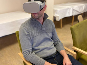 Mitarbeiter sitzend mit aufgesetzter VR-Brille.
