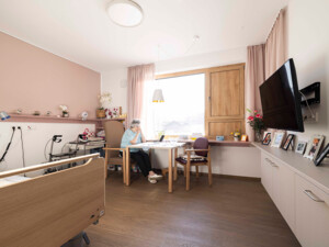 Ein Einbettzimmer im Neubau des ÖJAB-Pflegewohnhauses Salzburg - Wohlfühlen im Park mit Bewohnerin. Foto: ÖJAB / Erika Mayer.