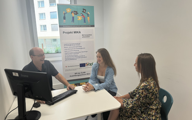 Zwei Teilnehmerinnen sitzt bei einem Trainer, um ihre gelernten Qualifikationen zu besprechen.