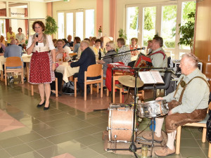 Heim- und Pflegedienstleiterin Elisabeth Muhr stehend mit Blasmusikkapelle.