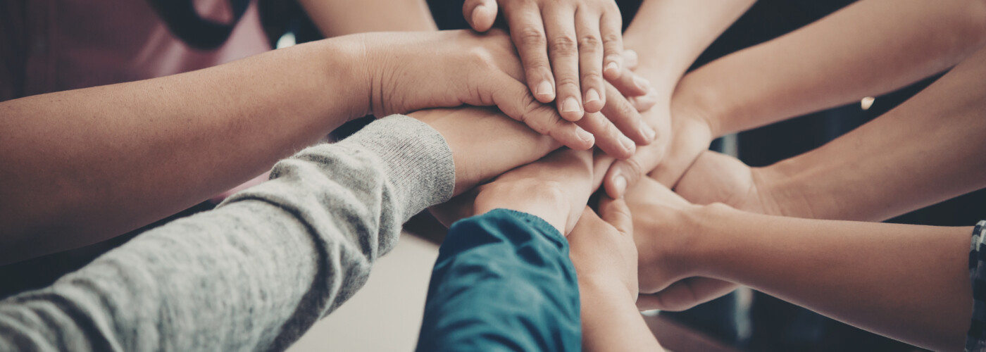 Symbolbild. Mehre Hände überneinander. Symbol für Gemeinschaft.