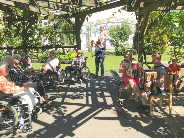 BewohnerInnen und MusikerInnen im Garten des ÖJAB-Hauses St.Franziskus.