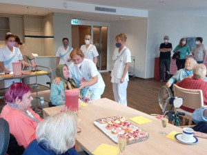 BewohnerInnen an Tischen im neuen ÖJAB-Pflegewohnhaus gemeinsam sitzend bei einem Sektempfang.