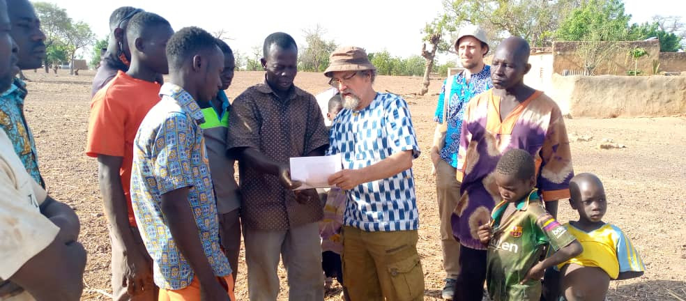 EZA-Projektmanager Oliver Böck (rechts im Hintergrund) und EZA-Konsulent Stephan Armbruster (links im Vordergrund) Hygiene- und Gesundheitsschulung vor Ort für Familienmitglieder der burkinischen Gemeinde Samba.