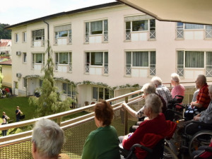 BewohnerInnen des ÖJAB-Hauses St. Franziskus am Balkon sitzend und dem Konzert im Garten lauschend.