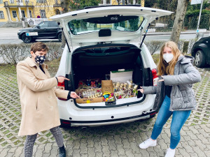 Zwei Projektteilnehmerinnen vor dem Auto, das mit den Ostergeschenken bepackt ist.