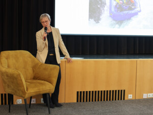 Eine Vortragende präsentiert vor Publikum im Veranstaltungssaal des Europahauses Wien.