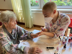 Bewohnerin erhält eine Maniküre von PflegemitarbeiterIn.