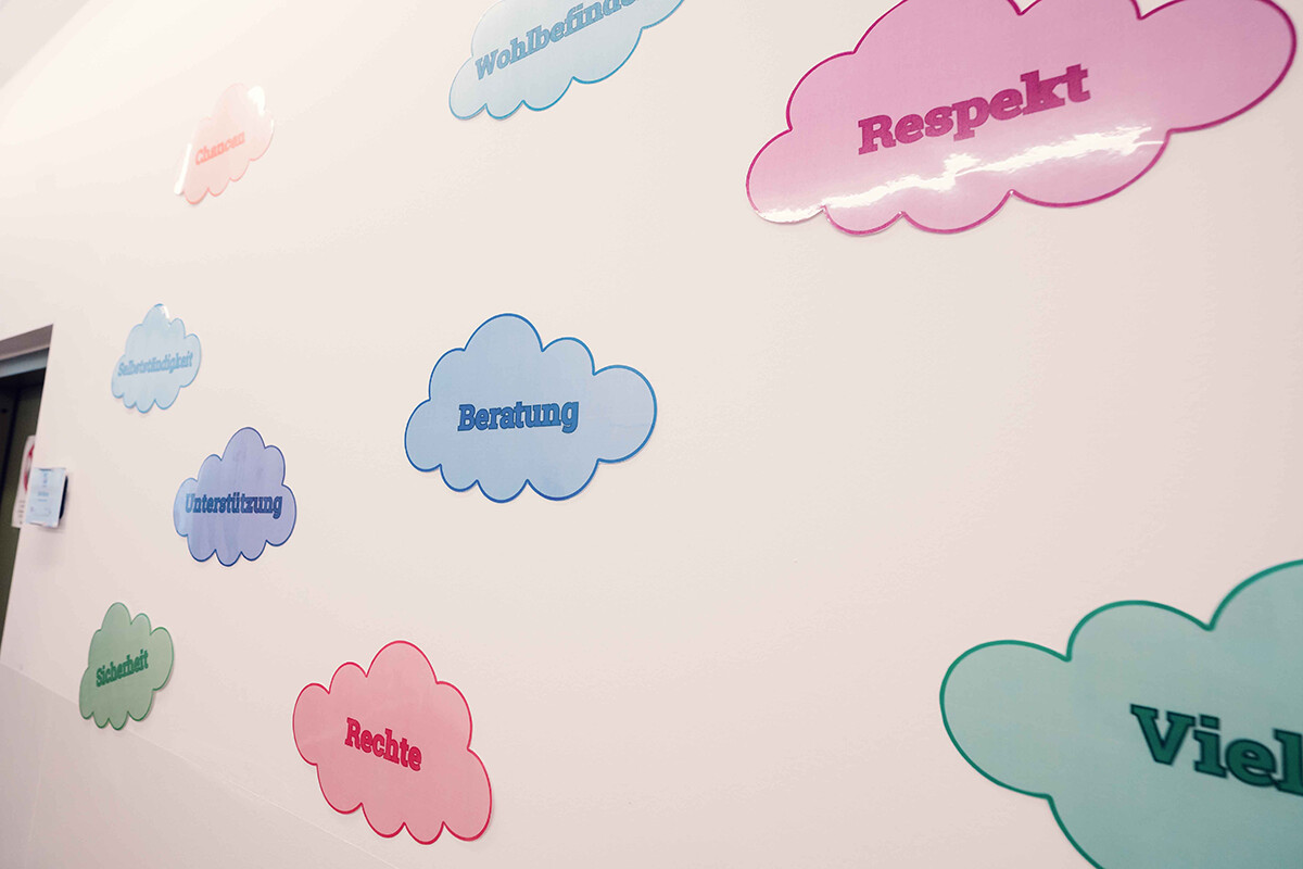 An einer hellen Wand hängen farbige Wolken mit Begriffen wie Beratung, Unterstützung, Rechte, Respekt, Wohlbefinden, Sicherheit und Ziele. Foto: www.inframe.at