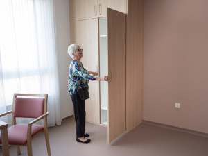 Seniorin stehend vor einem Kleiderschrank in einem Zimmer im neuen Pflegewohnhaus Neumargareten.