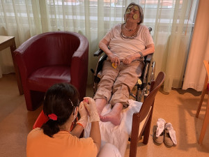 Bewohnerin erhält eine Fussmassage von PflegemitarbeiterIn.
