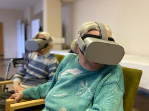 BewohnerInnen sitzend mit aufgesetzter VR-Brille.