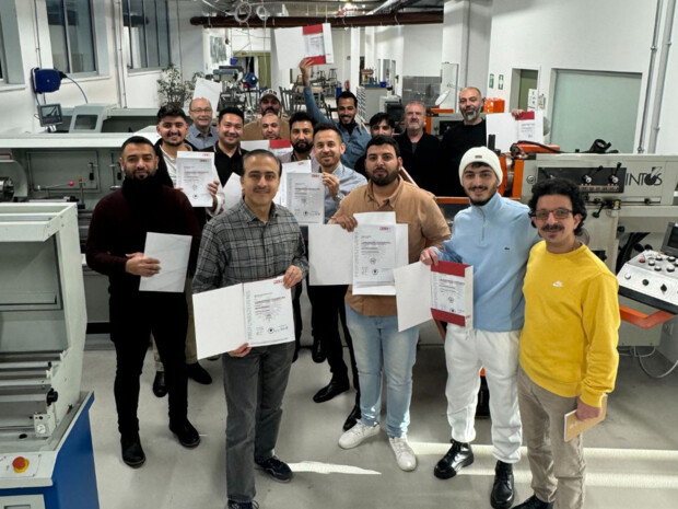 Gruppenfoto mit Zeugnissen in der Werkstatt 