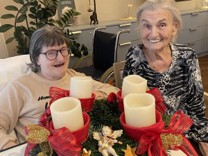 MitarbeiterInnen sind vor einem Adventkranz.