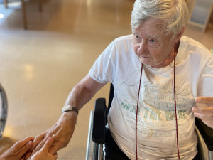 Bewohner erhält eine Handmassage von PflegemitarbeiterIn.
