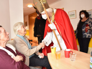 Frau Horvath und Frau Laky sitzend vor Nikolaus und Krampus in Begleitung von Seniorenbetreuerin Gerda.