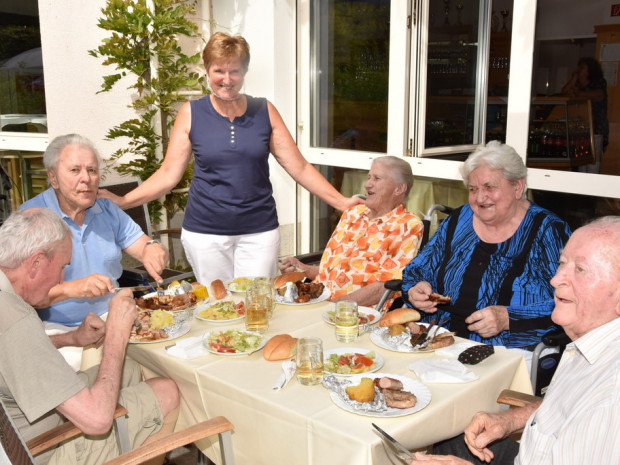 BewohnerInnen sitzend beim Grillfest 2020.