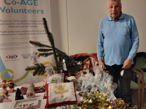 Herbert Bartl stehend vor einem Verkaufsstand im Haus.