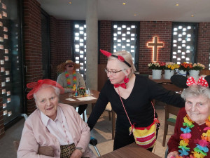 Bewohnerinnen sitzend mit Angehörigen, verkleidet.