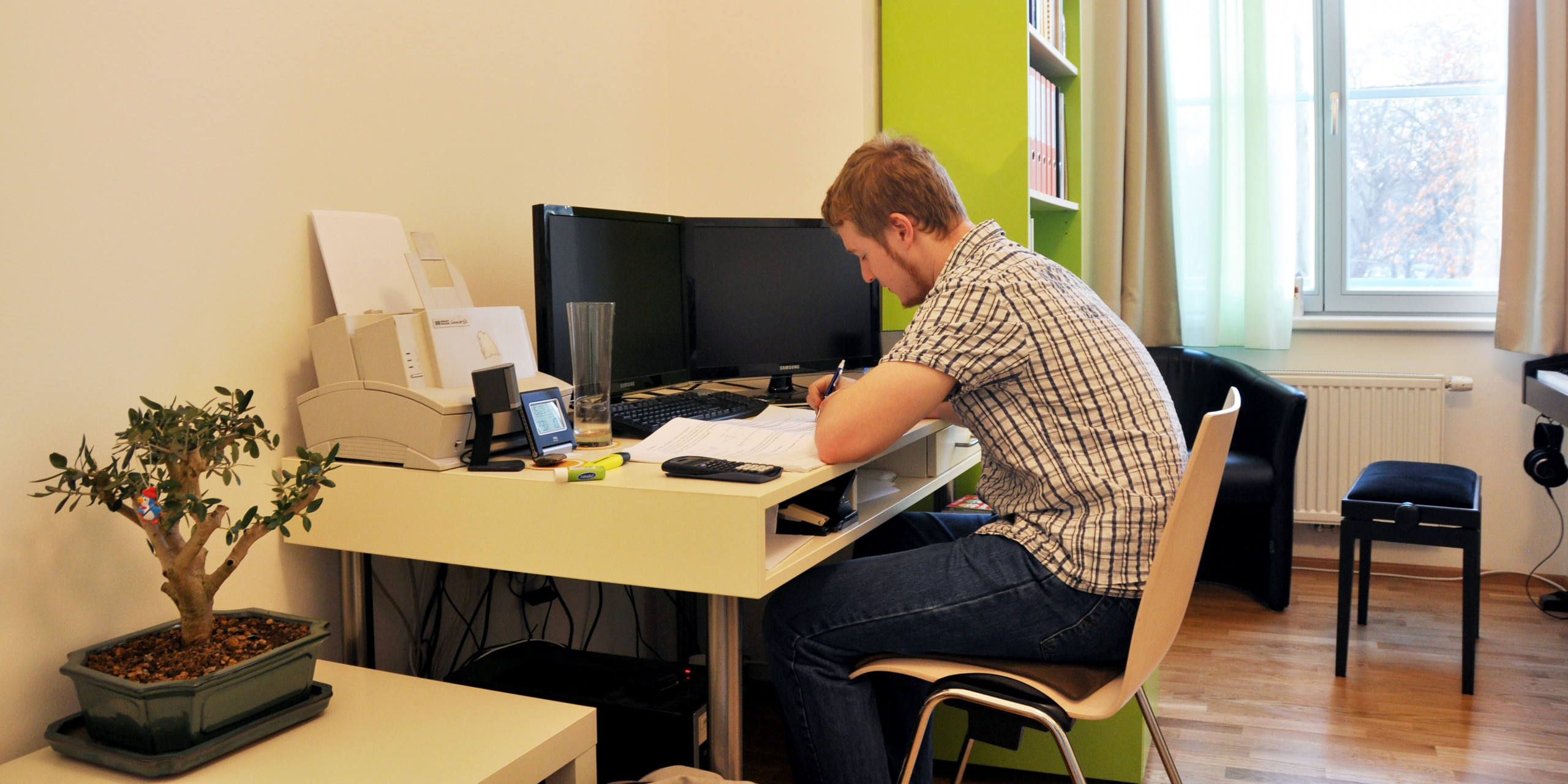 Symbolic image of a resident sitting at a desk in his dorm room.