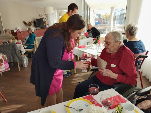 Senior bekommt ein Geschenk überreicht