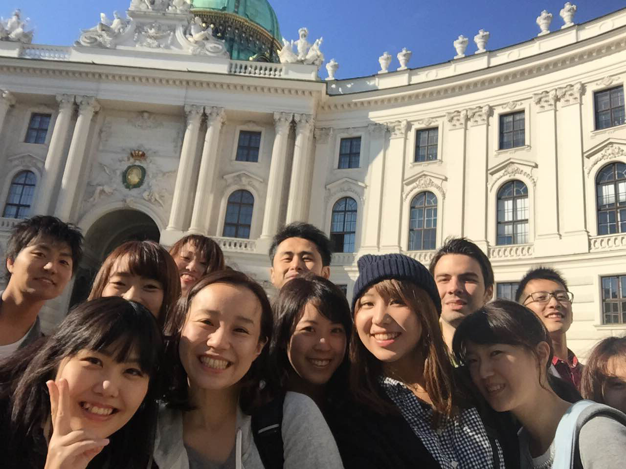 Japanische Jugendliche in Wien, im Hintergrund ist ein Teil der Wiener Hofburg sichtbar.